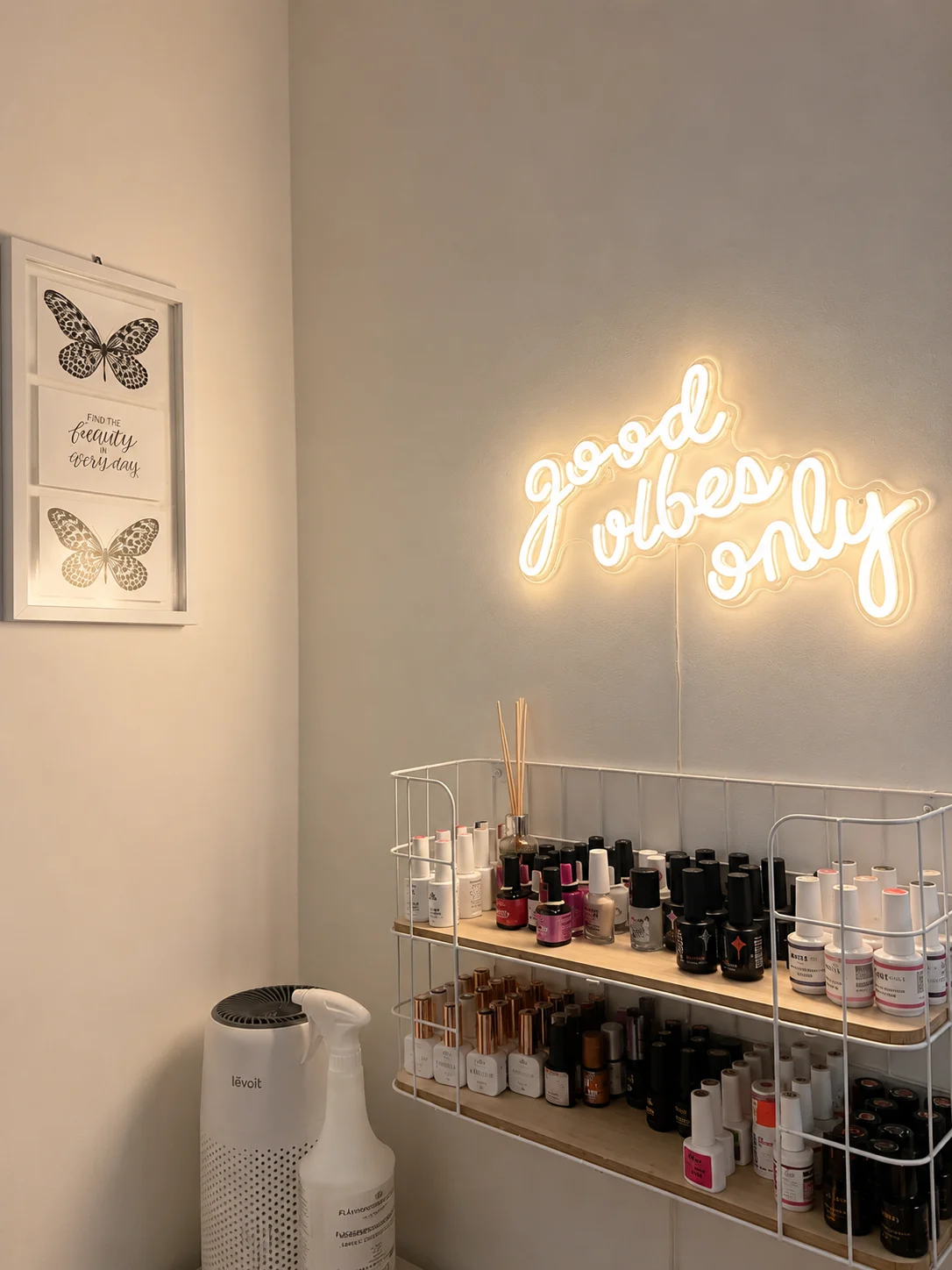 Studioecke mit Regal voller Gellacke und einem warm leuchtenden Neonschriftzug