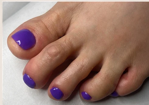 Fußnägel mit kräftig violettem Lack nach der Pediküre
